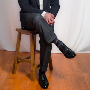 person wearing navy and grey horizontal striped dress socks with professional attire