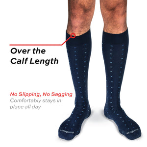 model wearing over the calf length cotton dress socks with a geometric pattern on a white background