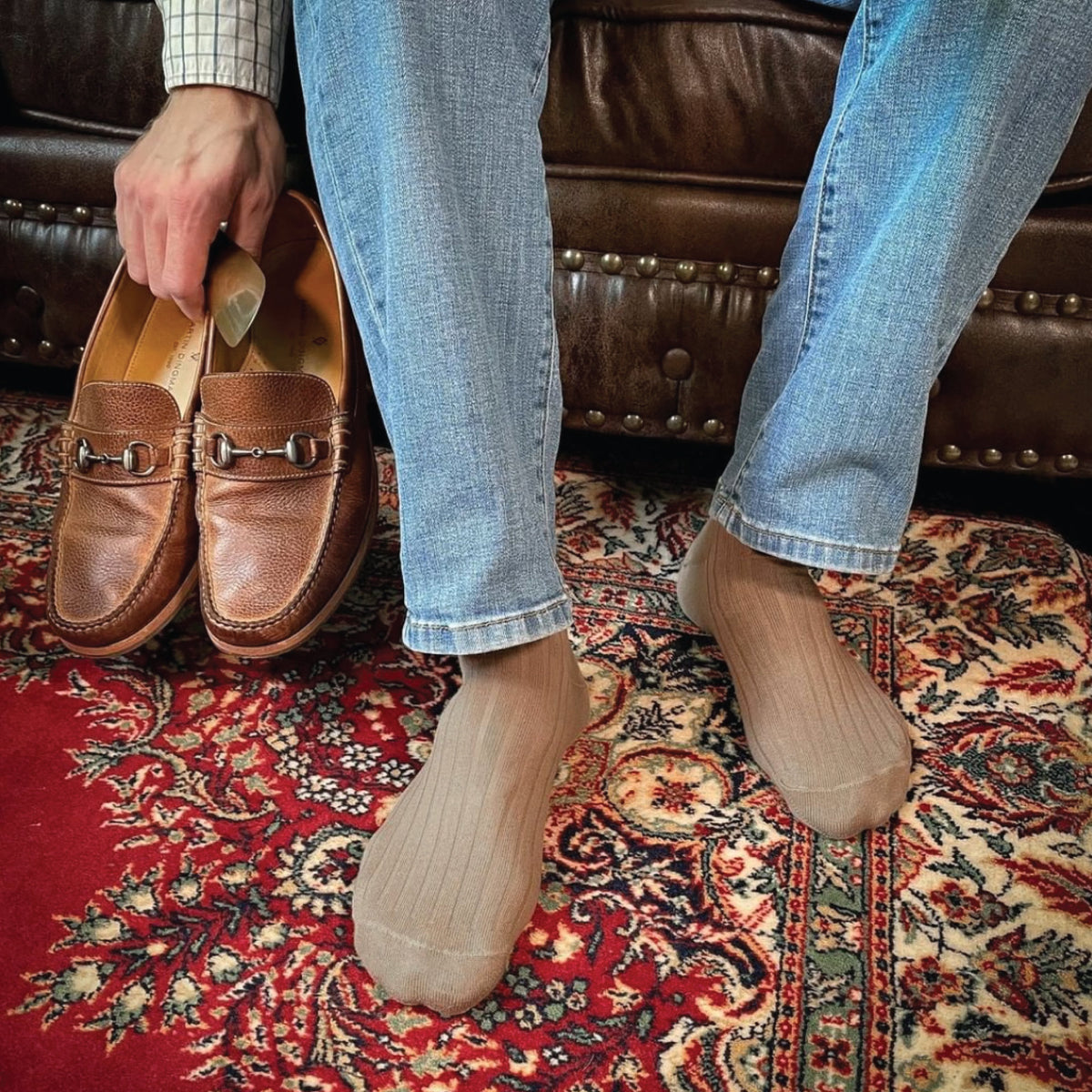 man sitting on a couch holding a pair of shoes while wearing Khaki Cotton Over the Calf Dress Socks