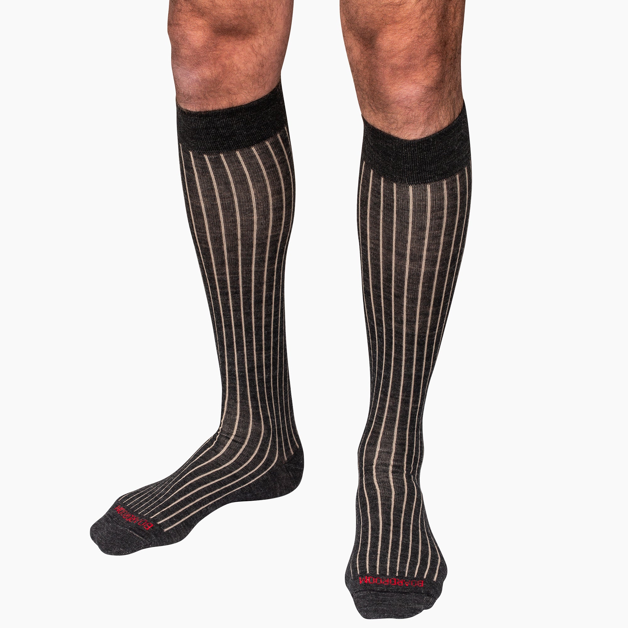 model wearing charcoal grey over the calf dress socks in unique shadow stripe pattern