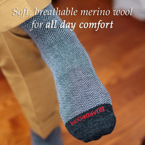 man wearing grey herringbone merino wool dress socks and khaki slacks crossing legs