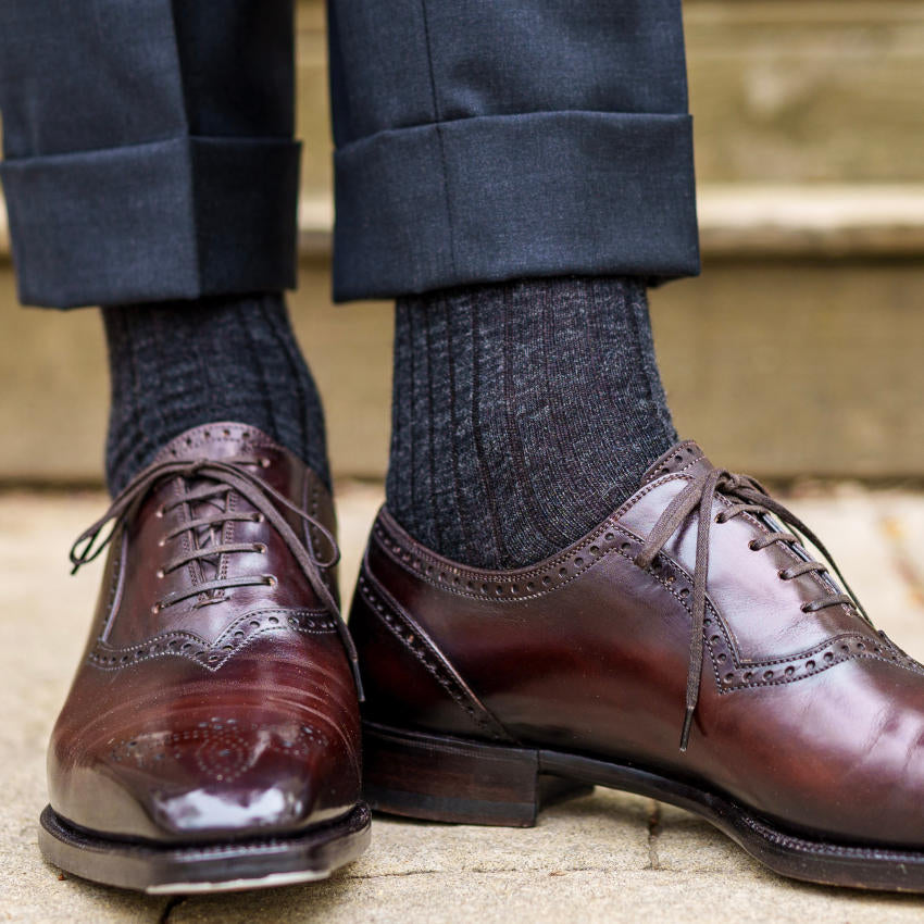 man standing wearing charcoal grey wool dress socks with dark brown dress shoes