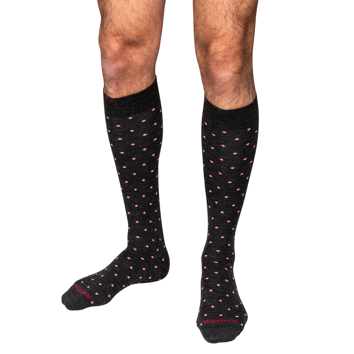 charcoal knee-high dress socks with pink polka dots worn by a person on a white background