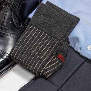 pair of charcoal and tan shadow stripe dress socks atop charcoal slacks and black oxford dress shoes