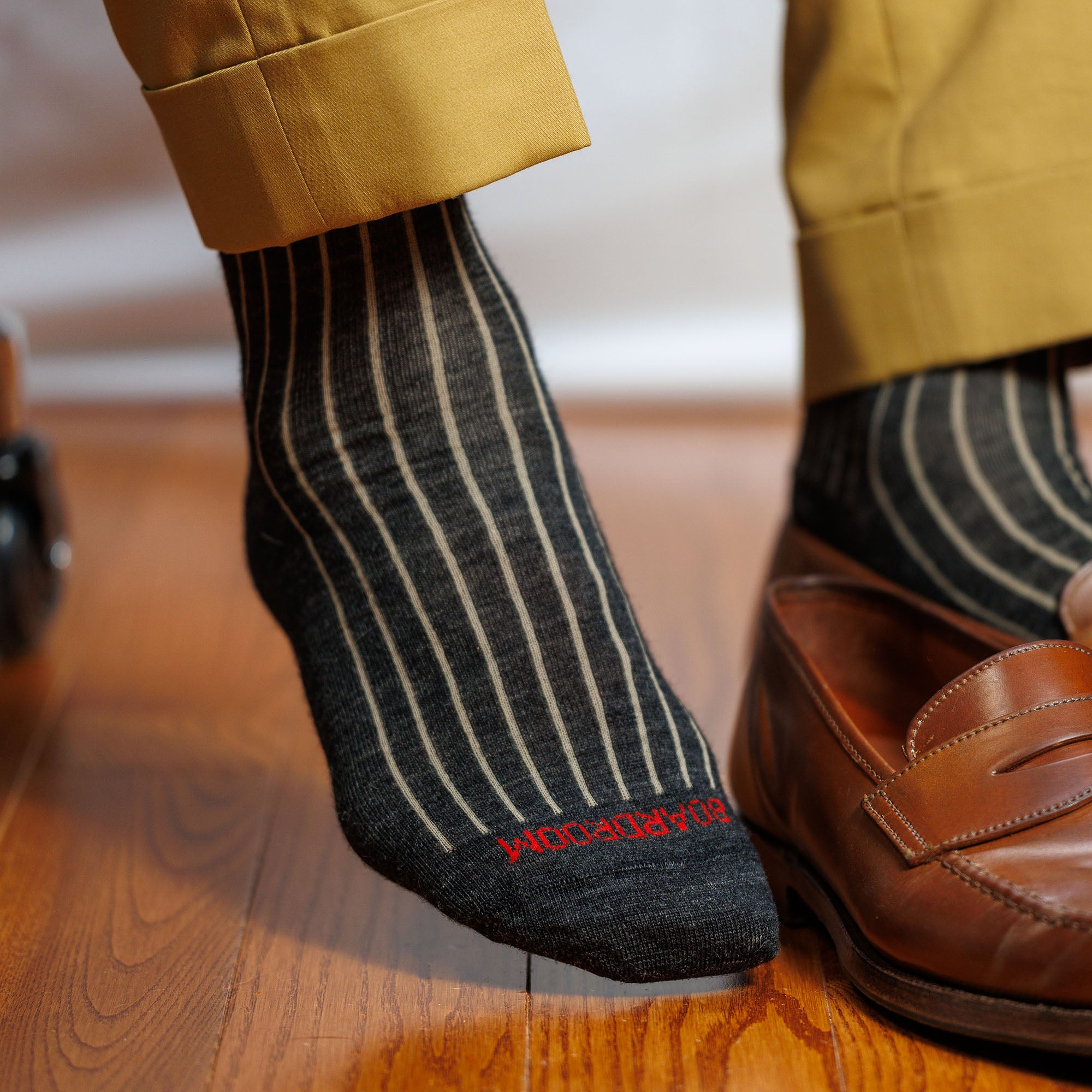 charcoal and tan vertical stripe wool dress socks worn with tan slacks and brown penny loafers