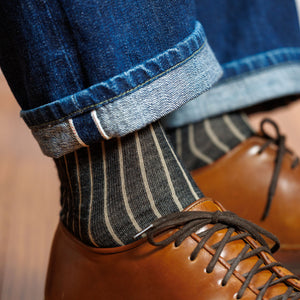 man wearing charcoal and tan shadow stripe dress socks with jeans and brown leather sneakers