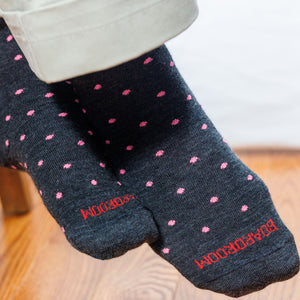 charcoal grey socks with pink polka dots and 'Boardroom' branding on a wooden floor.