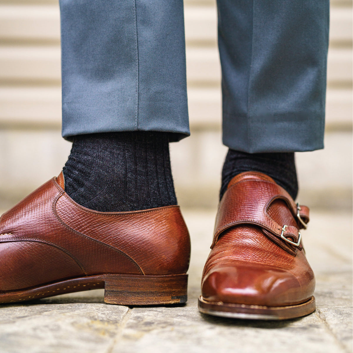 man standing wearing brown dress shoes and charcoal over the calf length wool dress socks 