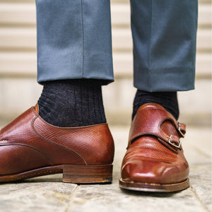 man standing wearing brown dress shoes and charcoal over the calf length wool dress socks 