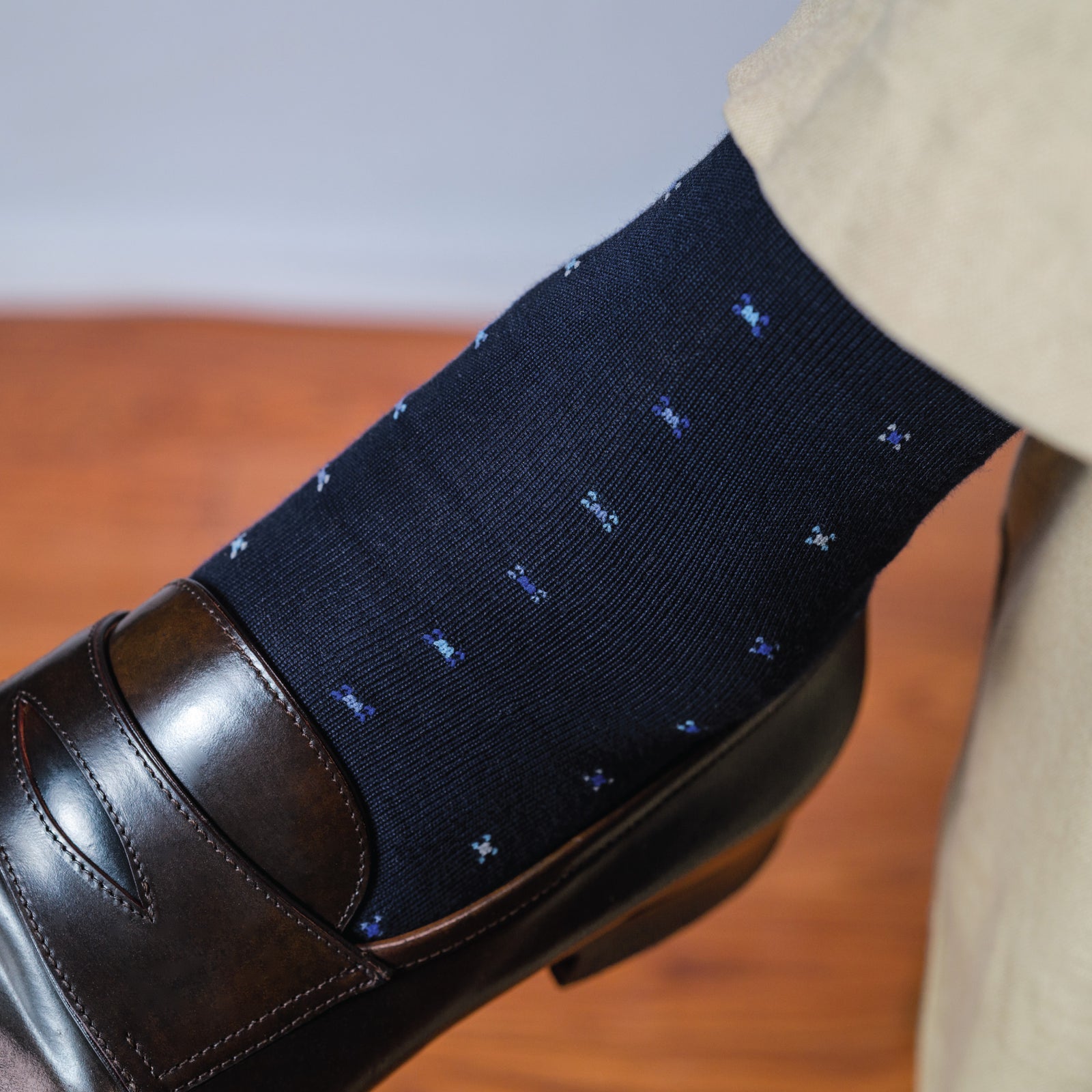 close up image of man wearing khakis and Navy Geometric Merino Wool Over the Calf Dress Socks