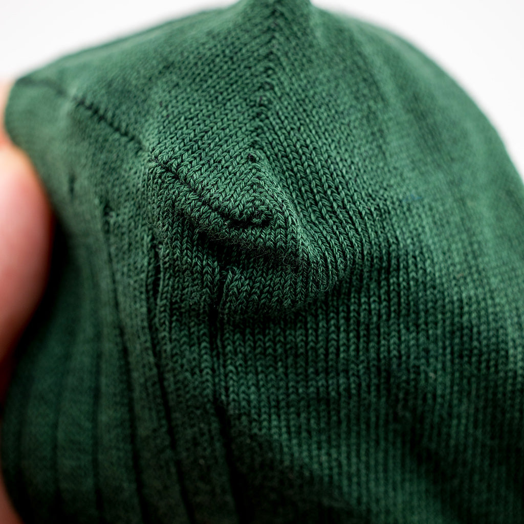 man holding forest green cotton dress sock
