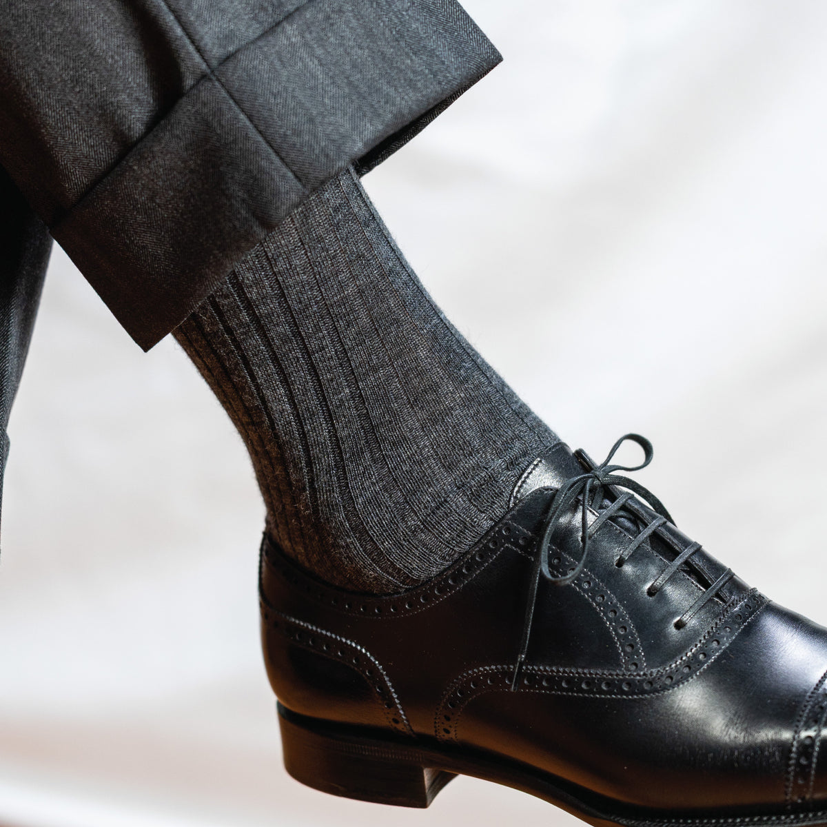 man wearing grey pants, black shoes and grey heather merino wool dress socks 