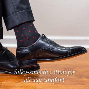 man wearing black and red polka dot dress socks with a dark suit