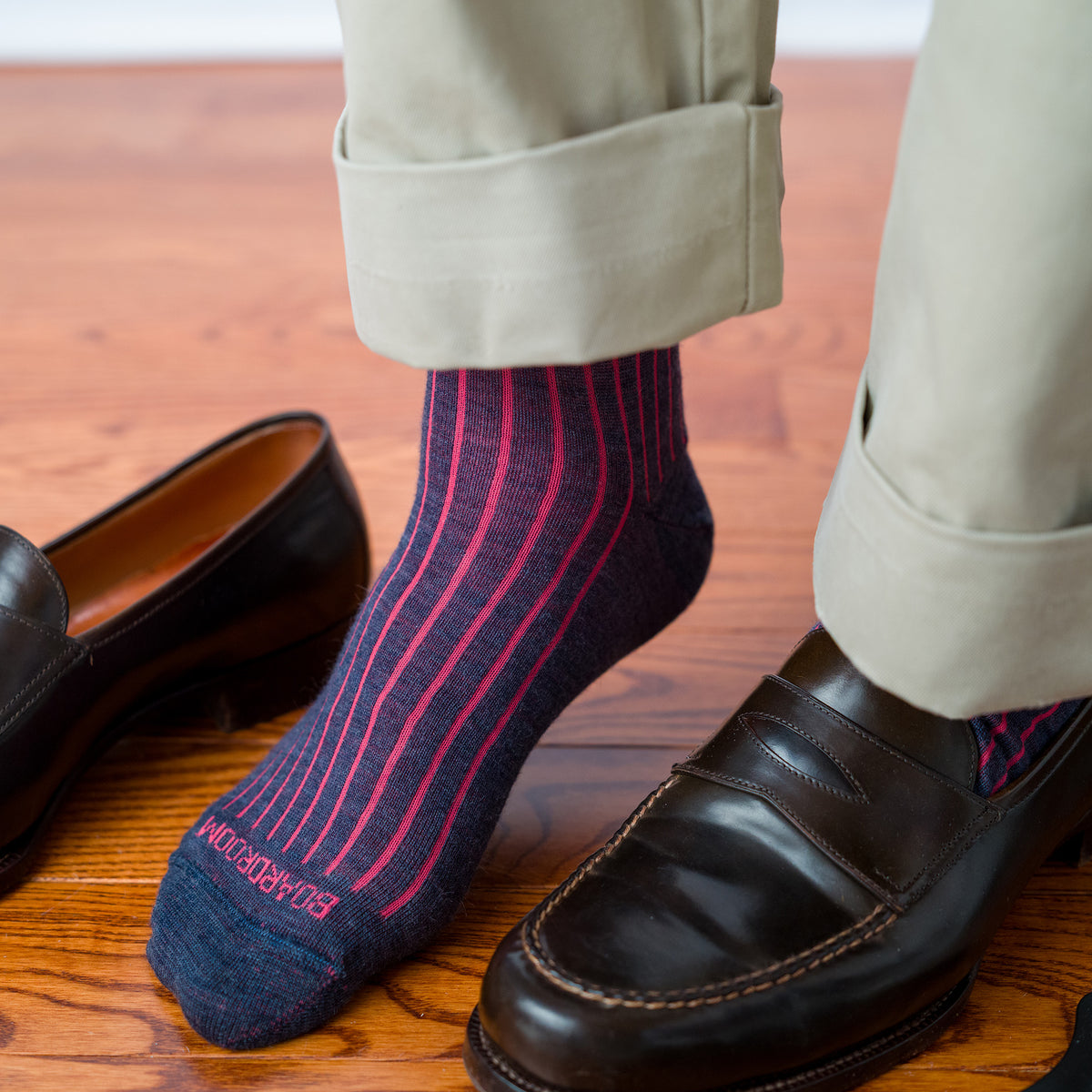 man wearing coral and denim shadow stripe dress socks with khakis and brown leather penny loafers