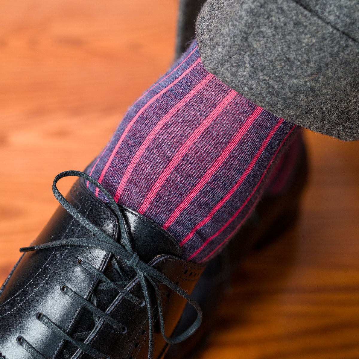 man wearing coral and denim wool shadow stripe dress socks with grey slacks and black oxfords