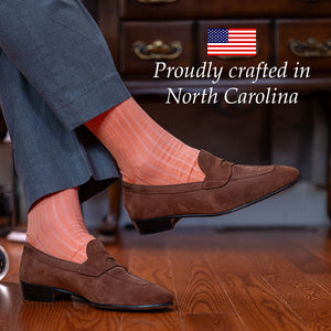 peach colored ribbed dress socks with grey slacks and light brown suede penny loafers