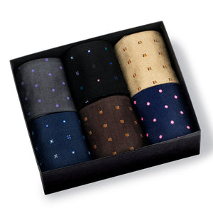 6 pairs of rolled up socks placed neatly in a black box sitting on a white background