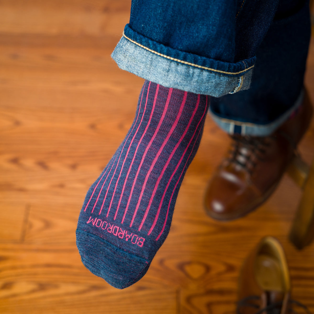 man wearing denim and coral wool shadow stripe dress socks with jeans and brown leather sneakers