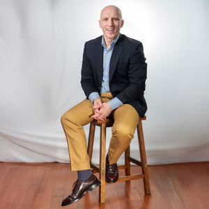 well dressed model still on a stool wearing heather blue mid calf dress socks
