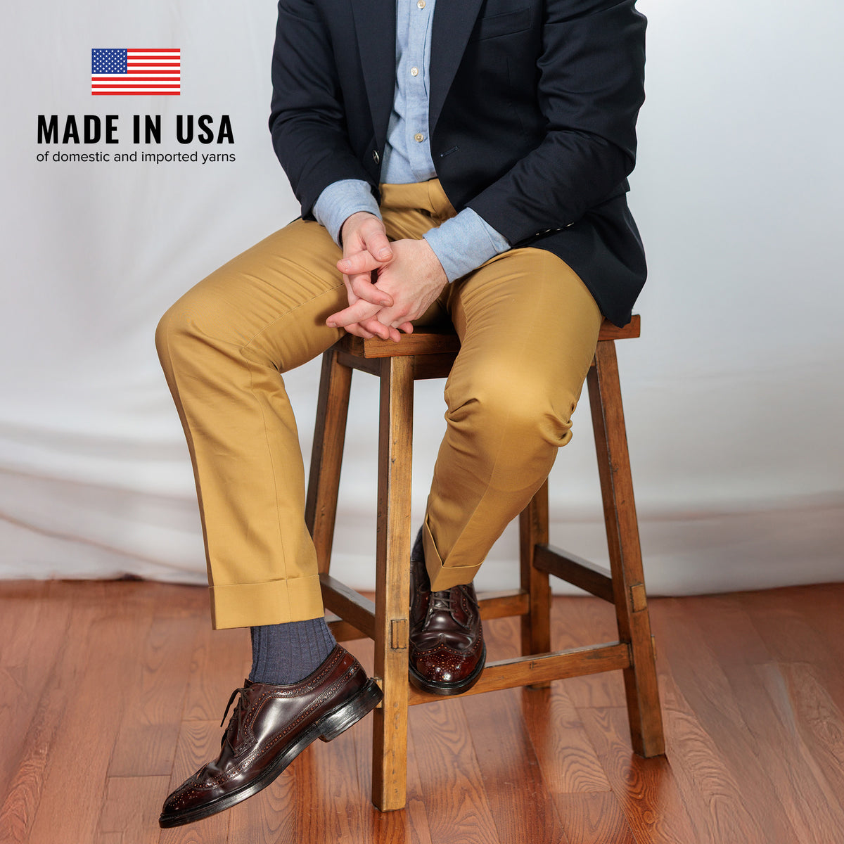 professional gentleman sitting on stool wearing denim heather merino wool dress socks