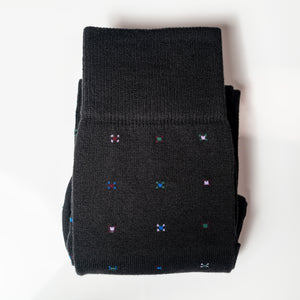 a pair of black geometric cotton dress socks folded on a white background