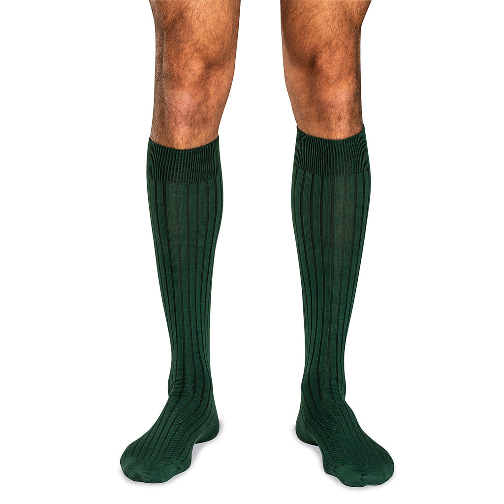 model wearing forest green over the calf dress socks for men