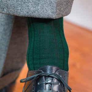 close up image of a person wearing Forest Green Merino Wool mid-Calf Dress Socks with nice black shoes