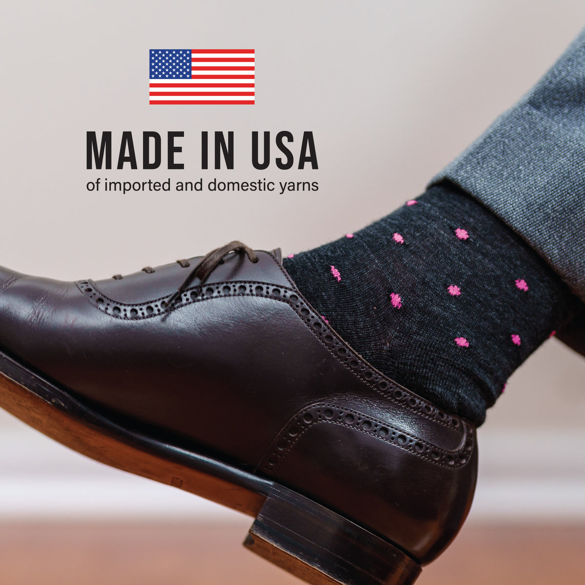 man wearing nice clothes and black dot patterned merino wool dress socks with made in usa text voerlay