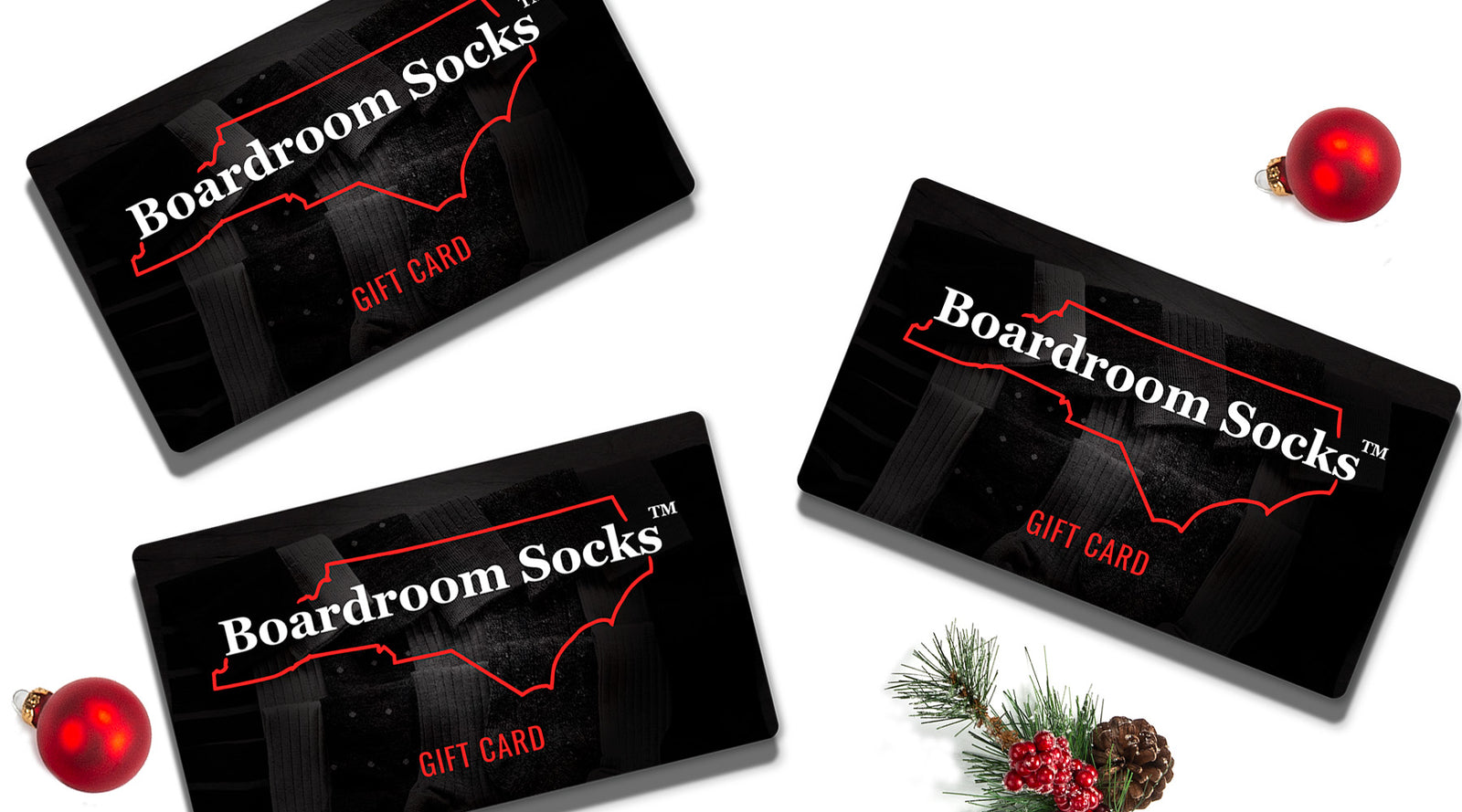 three Boardroom Socks gift cards surrounded by holiday decor