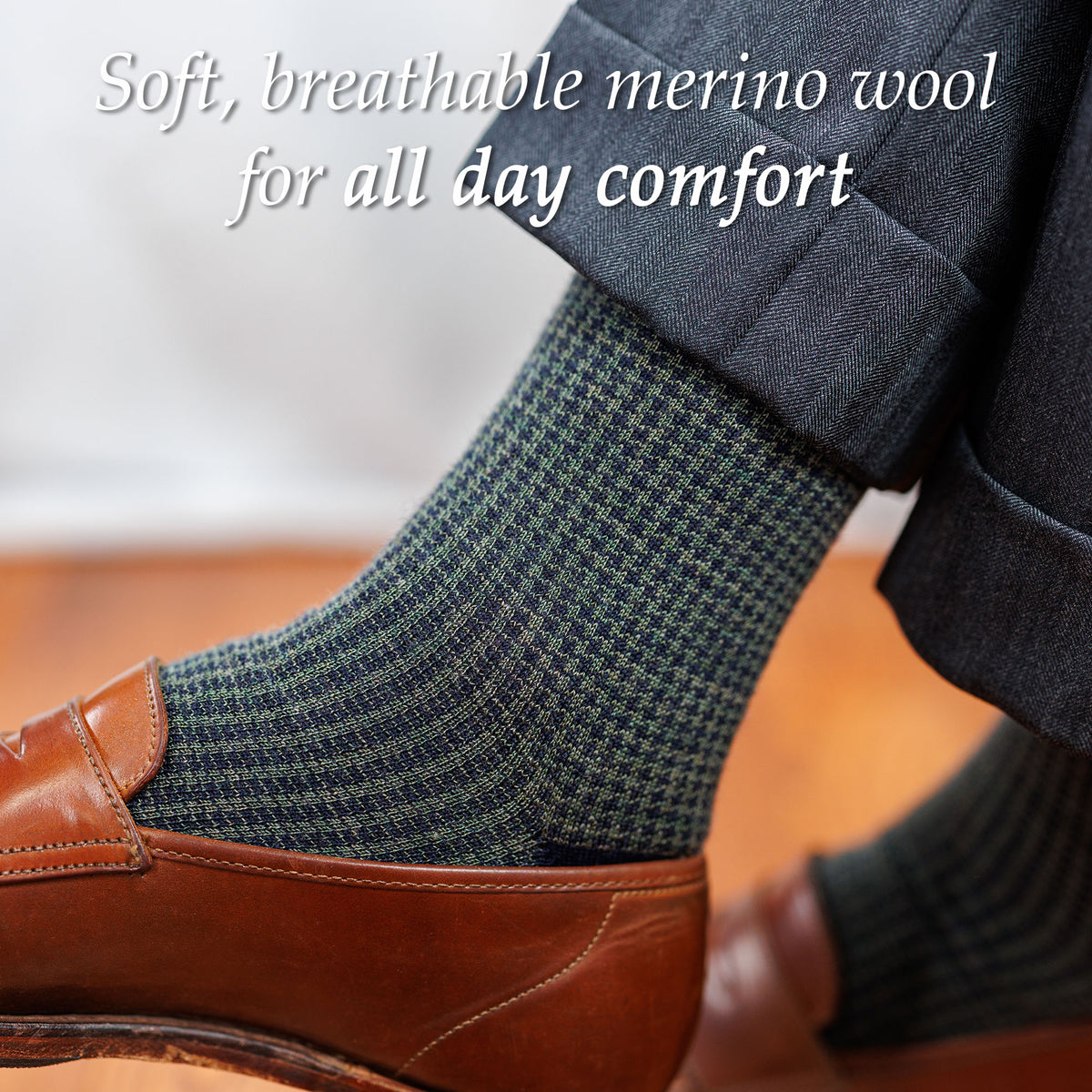man wearing olive and navy houndstooth dress socks with charcoal suit and brown penny loafers