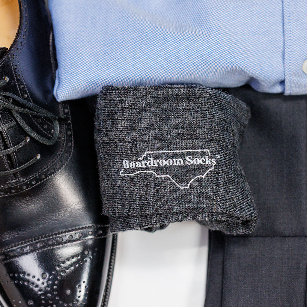 pair of grey heather merino wool dress socks from Boardroom Socks atop business casual outfit