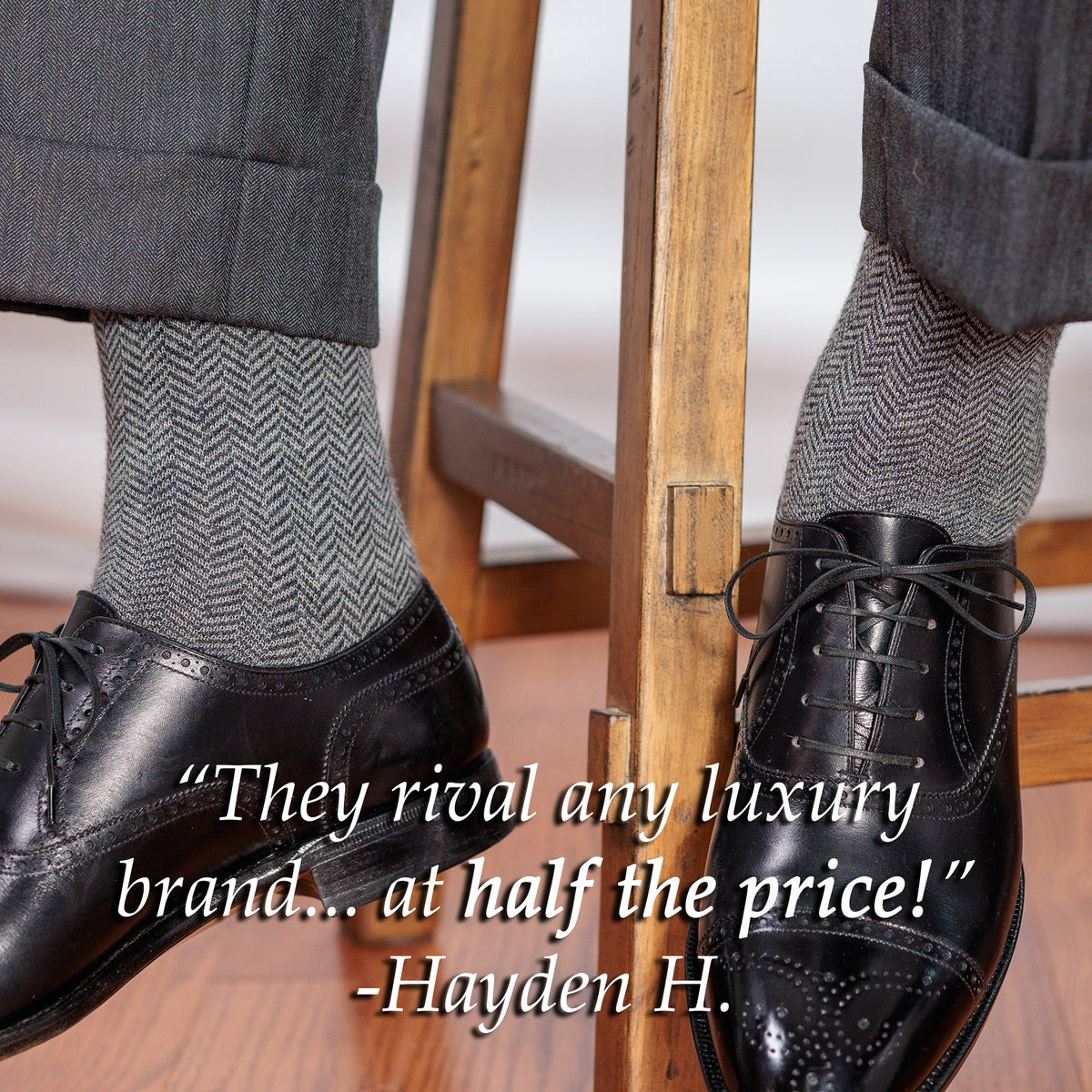 man sitting on stool wearing grey herringbone dress socks with grey slacks and black oxfords