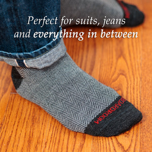 man standing on hardwood floor wearing grey herringbone dress socks with jeans