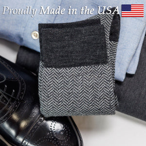 pair of grey herringbone dress socks folded atop a business casual outfit