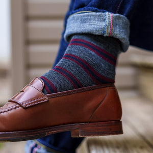 man wearing jeans and grey striped dress socks with brown penny loafers