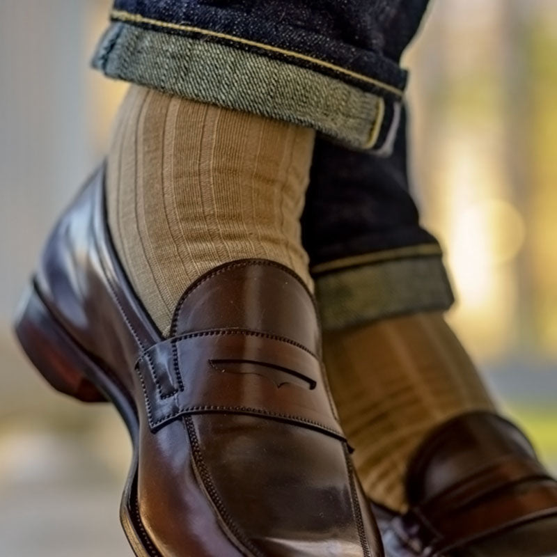 man wearing ribbed khaki dress socks with cuffed jeans and dark brown penny loafers