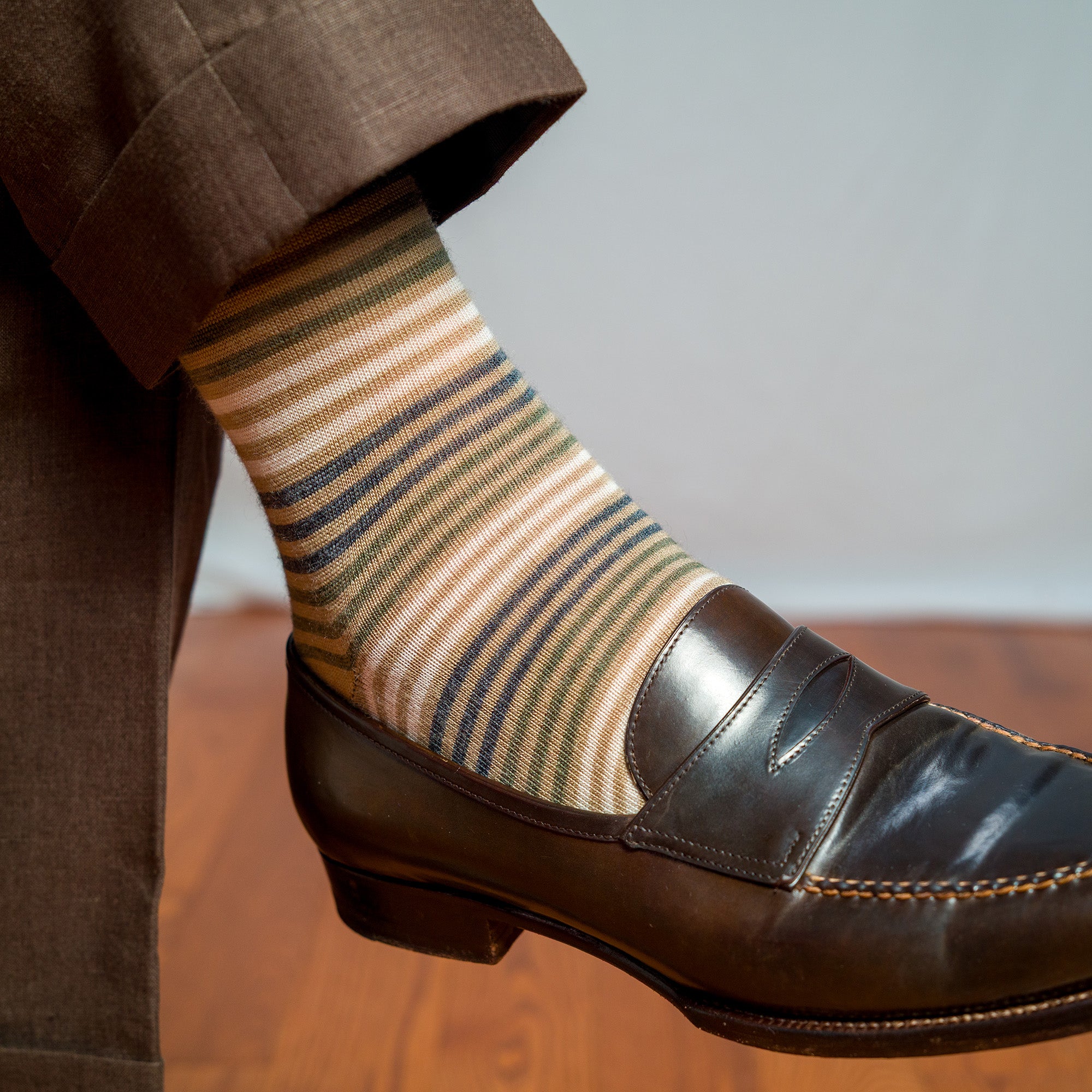 khaki dress socks with colorful stripes paired with brown slacks and brown penny loafers