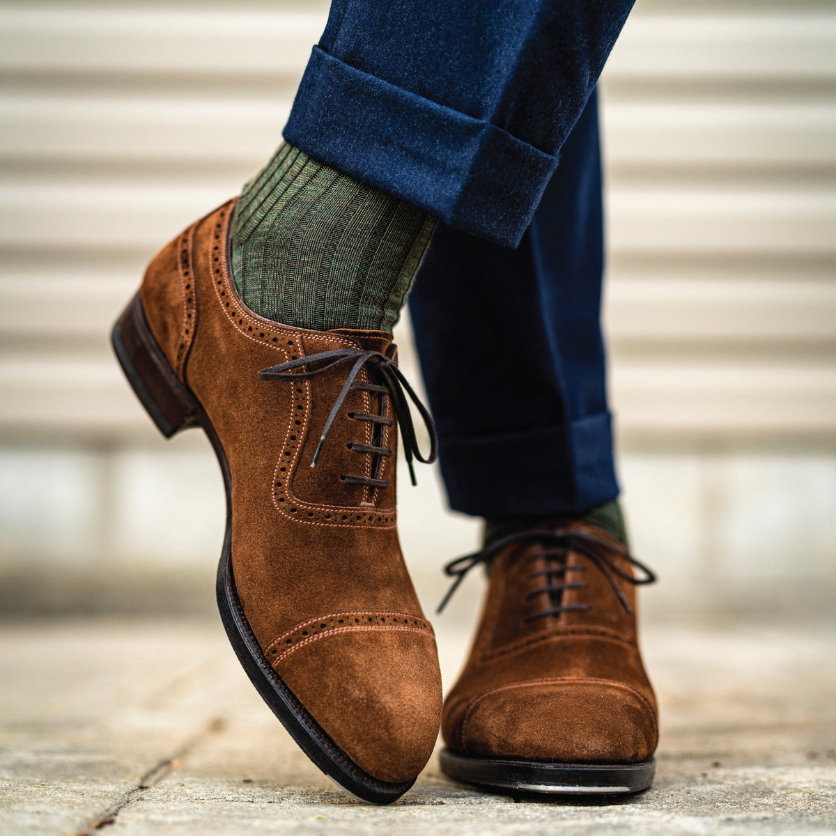 man crossing his feet standing wearing olive merino wool over the calf ribbed mens dress socks