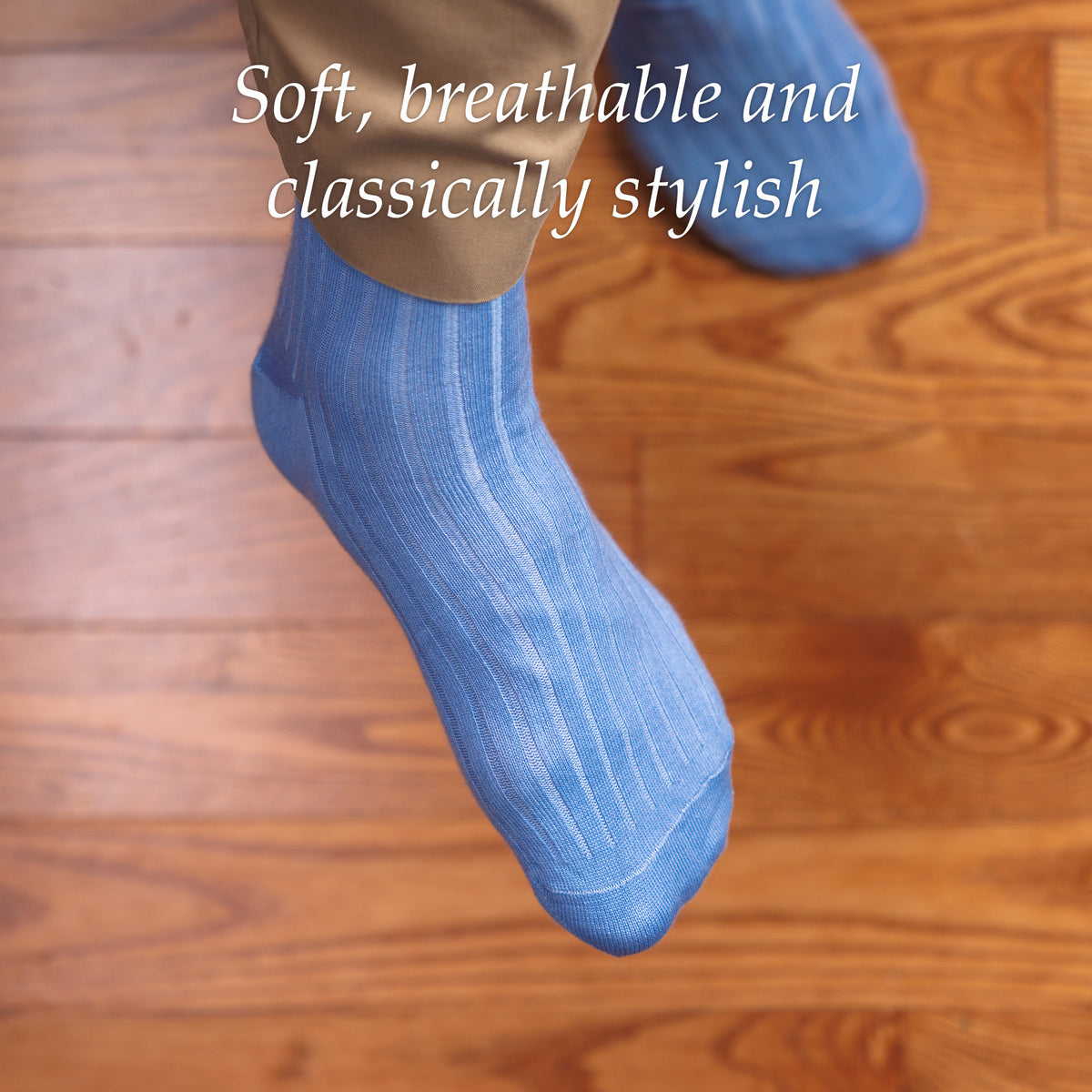man crossing legs wearing sky blue ribbed dress socks with khakis