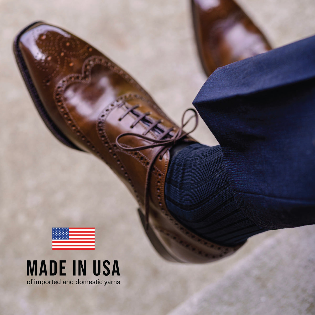 close up image of a man wearing brown shoes, navy pants and Navy Cotton Mid Calf Dress Socks