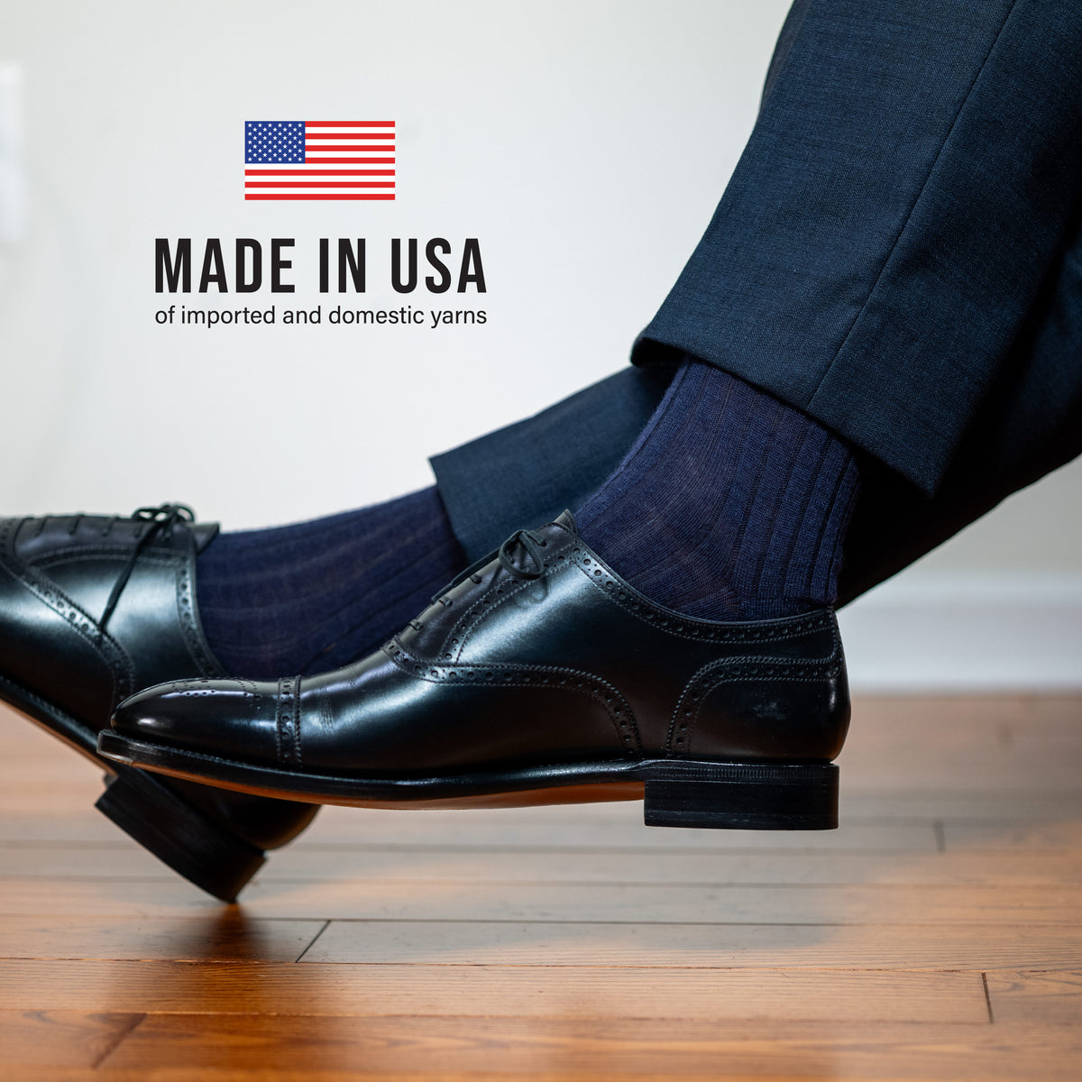man crossing legs wearing navy wool over the calf mens ribbed dress socks with made in usa text overlay