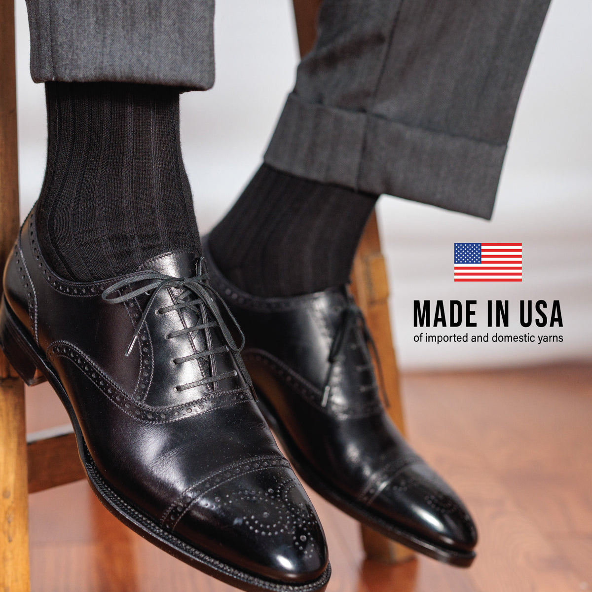 man sitting on a stool wearing nice clothes and shoes with Black Cotton Mid Calf Dress Socks