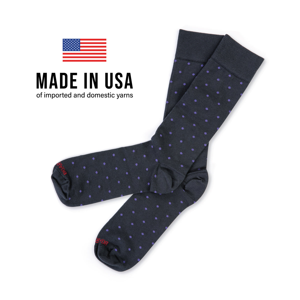 pair of mid-calf length grey cotton dress socks with purple polka dots laid flat on a white background