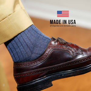 close up image of model's left foot wearing denim wool dress socks with made in usa overlay
