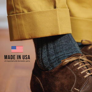 close up image of man wearing grey heather merino wool dress socks with made in usa text overlay
