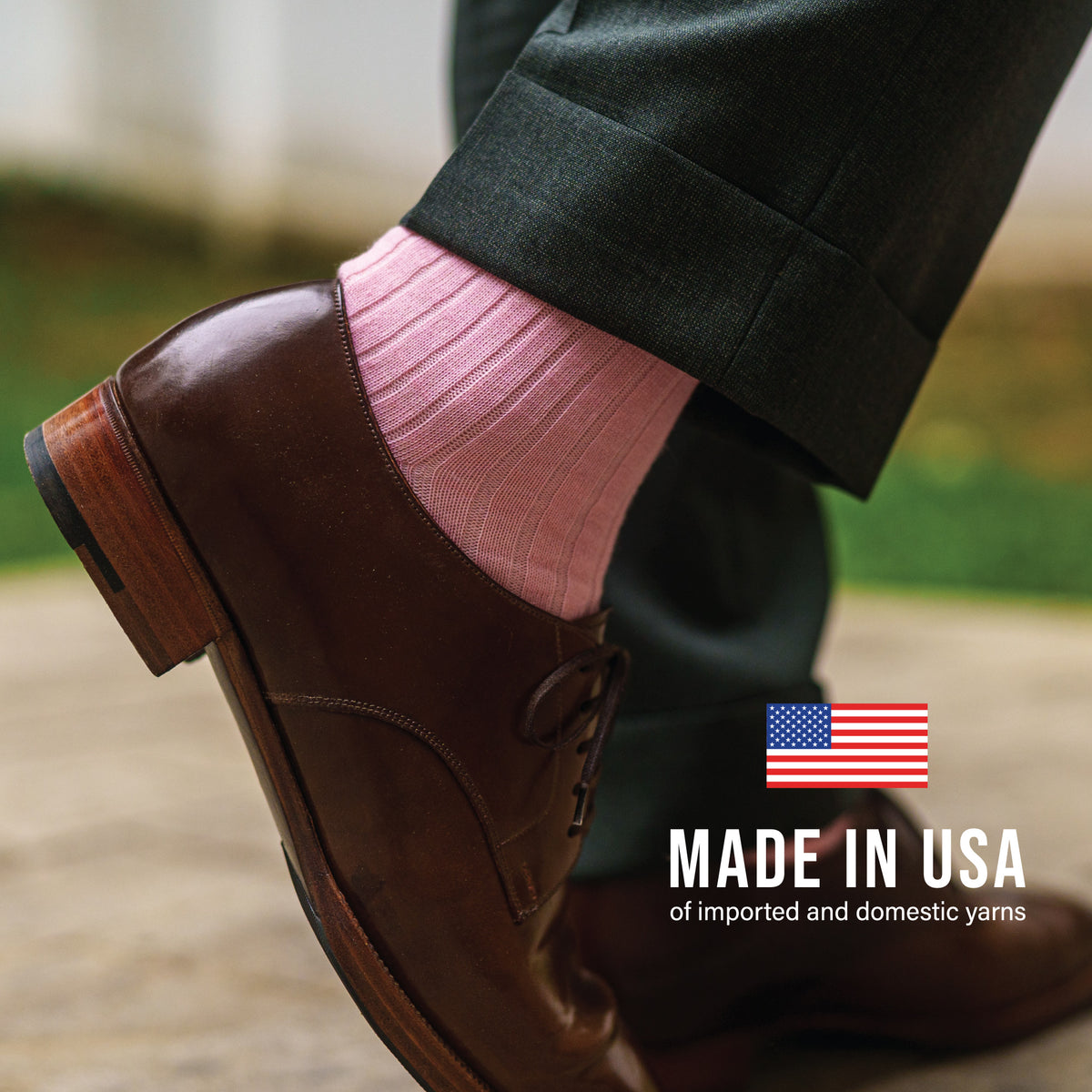 man standing outside wearing pink merino wool dress socks and brown shoes