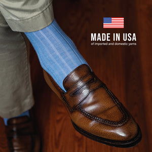 model wearing khakis and sky blue merino wool mid-calf length ribbed mens dress socks with made in the usa text overlay