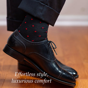 man crossing ankles wearing black and red patterned dress socks with black oxfords
