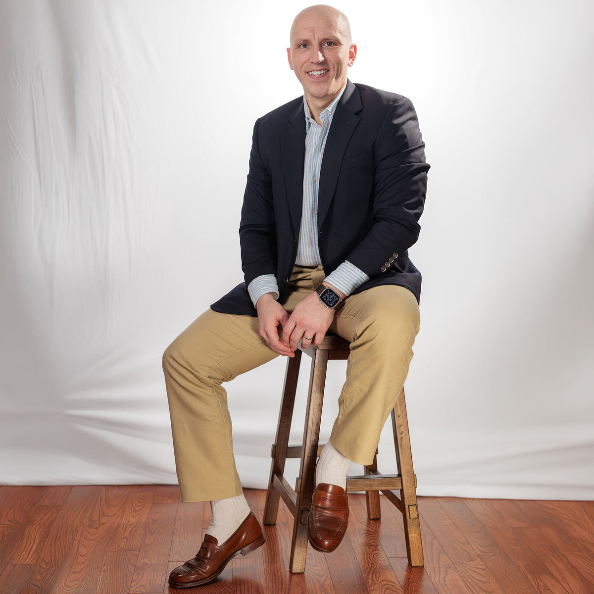 man wearing white dress socks with business casual outfit while sitting on stool