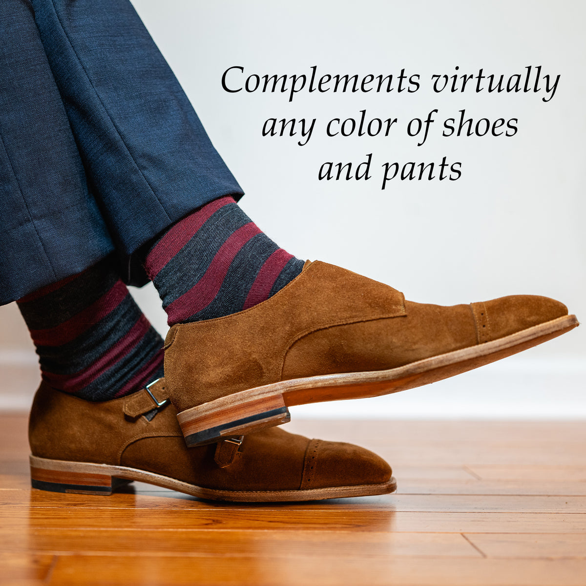 man wearing striped burgundy and dark gray dress socks with brown suede dress shoes and a navy suit